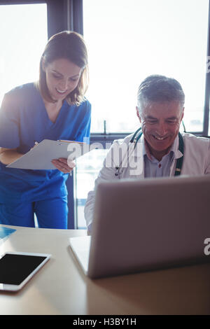 Doctor discussing with nurse over laptop Stock Photo