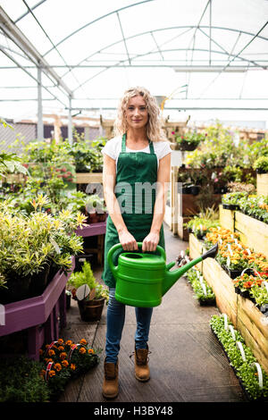 Female florist holding watering can Stock Photo