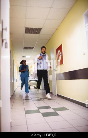 Doctor and nurse running in hospital corridor Stock Photo