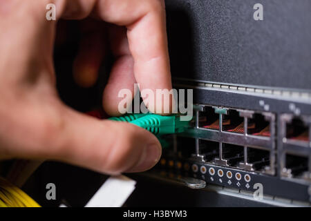 Technician connecting ethernet in socket Stock Photo