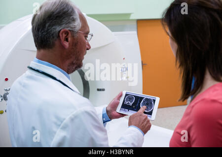 Doctor explaining to patient about brain mri scans on tablet Stock Photo