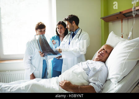 Doctors interacting over x-ray report with patient Stock Photo