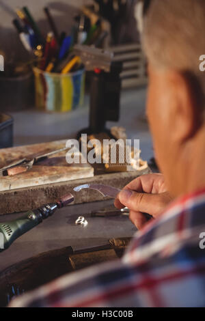 Goldsmith using hand piece machine Stock Photo