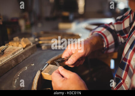 Goldsmith shaping metal with pilers Stock Photo