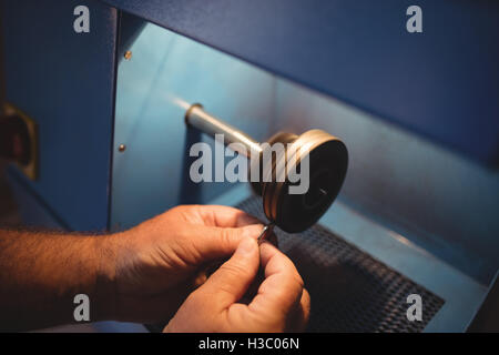 Goldsmith polishing ring in workshop Stock Photo