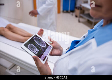 Doctor looking at brain mri scan on digital tablet Stock Photo