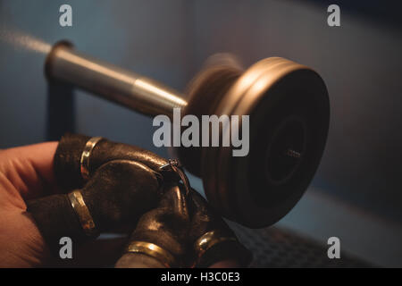 Goldsmith polishing ring in workshop Stock Photo