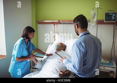 Nurse consoling senior patient with doctor Stock Photo