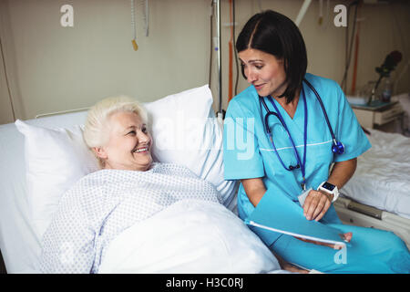 Nurse interacting with senior patient Stock Photo