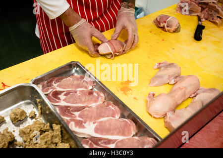 Mid section of butcher preparing a chicken and steak roll Stock Photo