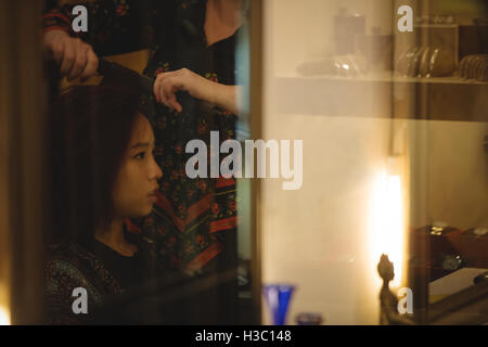 Woman is getting her hair straightened Stock Photo