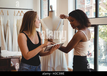 Female fashion designers working on a digital tablet Stock Photo