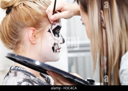 Beautiful girl with face art on Halloween, black and white skull