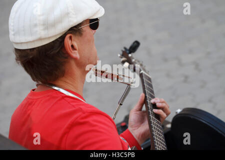 Street musician playing guitar and harmonica, lifestyle, travel, art Stock Photo