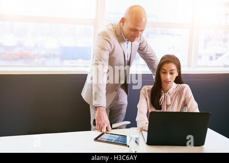 Businesswoman being supervised by her male superior while working Stock Photo