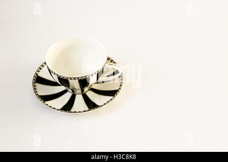 A beautiful black and white striped cup and saucer isolated on white. Stock Photo