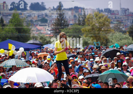 QUITO, ECUADOR - JULY 7, 2015: Just for a photo a woman is satnding up on a men shoulders, mobile phone camera on her hands Stock Photo