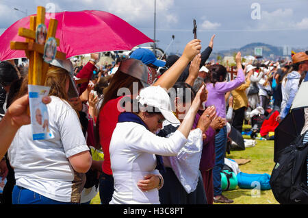 QUITO, ECUADOR - JULY 7, 2015: People raising her hands to receive pope Francisco blessings in his mass, taking care of sun Stock Photo