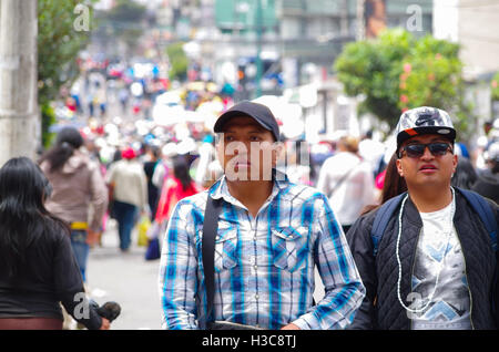 QUITO, ECUADOR - JULY 7, 2015: Two unidentified mens walking in the middle of the event, full of people. Pope Francisco mass Stock Photo
