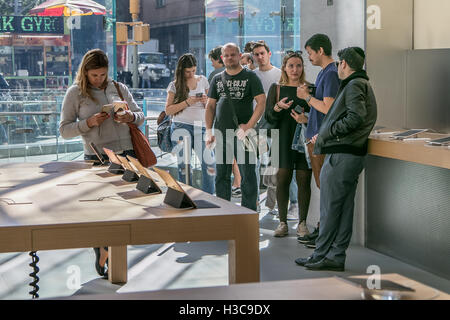 People stand in line in the Apple store on Manhattan's Upper West Side waiting to purchase a new iPhone. Stock Photo