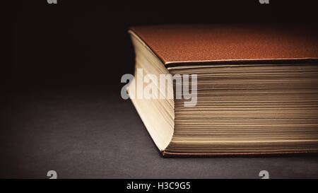 Closeup view on an old closed book, details of paper and leatherette cover. Stock Photo