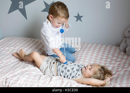 Children playing doctor with toy stethoscope Stock Photo