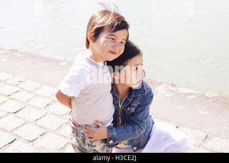 Young siblings embracing outdoors Stock Photo