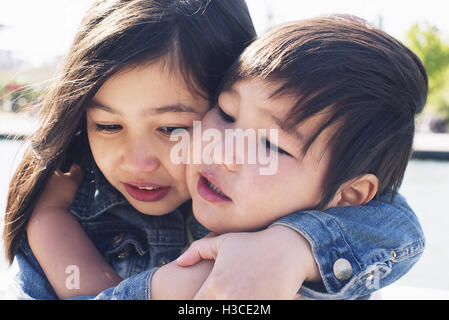 Young siblings embracing Stock Photo