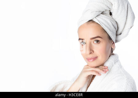 Pretty young woman with white towel on her head and light makeup, studio portrait Stock Photo