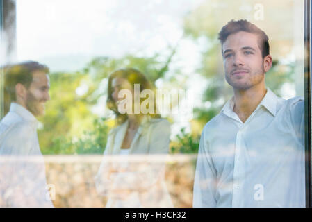 Businessman looking out window lost in thought Stock Photo