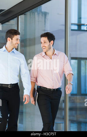 Business associates chatting while walking together Stock Photo