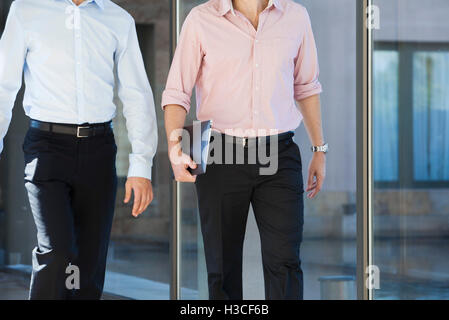 Businessmen walking in office corridor Stock Photo