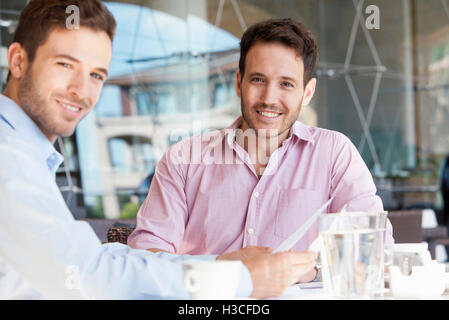 Insurance agent discussing contract with client over coffee Stock Photo