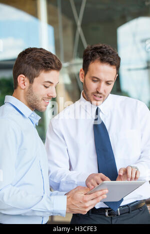 Businessmen collaborating using digital tablet Stock Photo