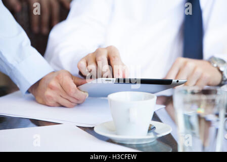 Businessmen discussing work using digital tablet over coffee Stock Photo