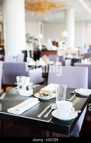 Place settings for breakfast in modern dining room Stock Photo