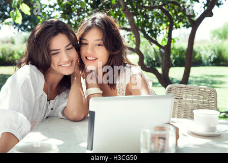 Woman friends taking off their clothes and throwing while running towards  the ocean. Excited women going for swimming in the sea on a summer day.  stock photo