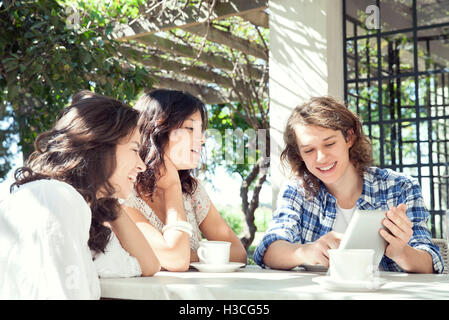 Young friends using digital tablet outdoors Stock Photo