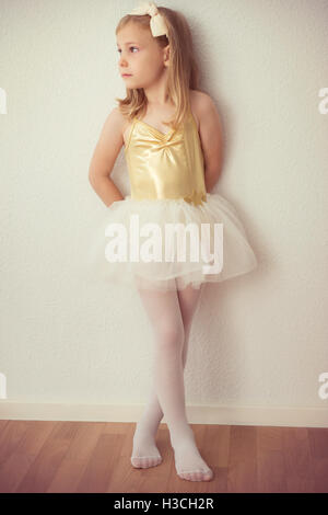 Pretty ballet child girl in white tutu staying at wall Stock Photo