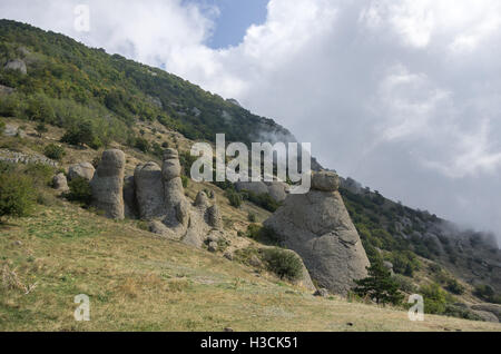 Low clouds on slope of the Demerdji mountain. The rock formations in Valley of Ghosts. Landscape of Crimea, Russia. Ukraine Stock Photo