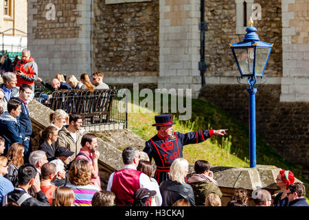 A Beefeater (Yeoman of the Guard) Giving A Tour At The Tower Of London, London, England Stock Photo