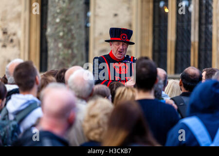 A Beefeater (Yeoman of the Guard) Giving A Tour At The Tower Of London, London, England Stock Photo