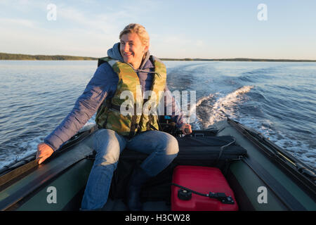 Smiling woman is operating of boat on the sea Stock Photo