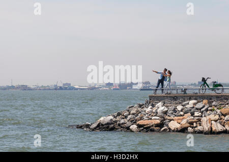 Couple standing on observation point by river against clear sky Stock Photo