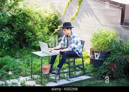 Man using laptop on terrace Stock Photo