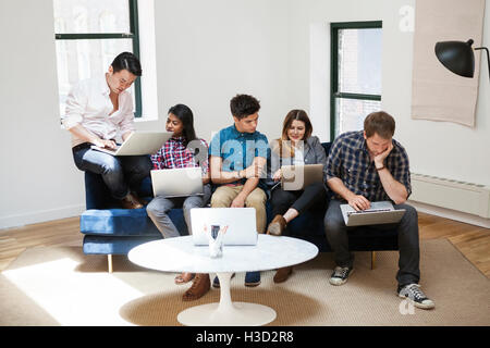Colleagues working on laptops in creative office Stock Photo