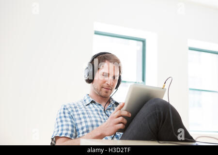 businessman using tablet computer while listening music in office Stock Photo