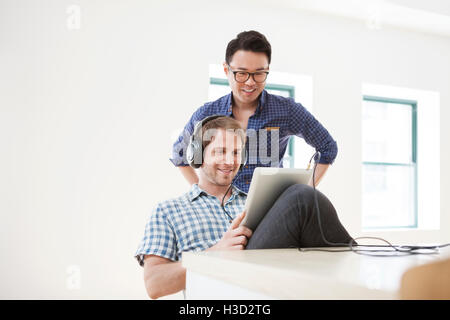Smiling businessmen using tablet computer in creative office Stock Photo