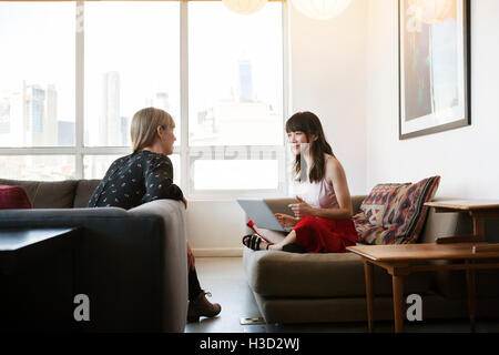 Smiling businesswoman talking to colleague in creative office Stock Photo