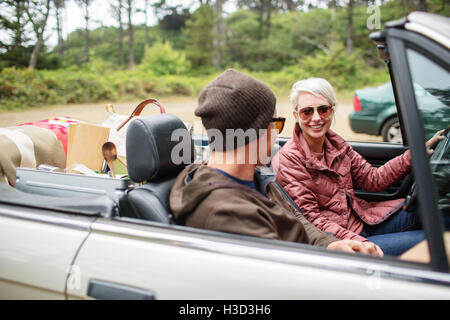 Happy woman sitting with man in convertible Stock Photo